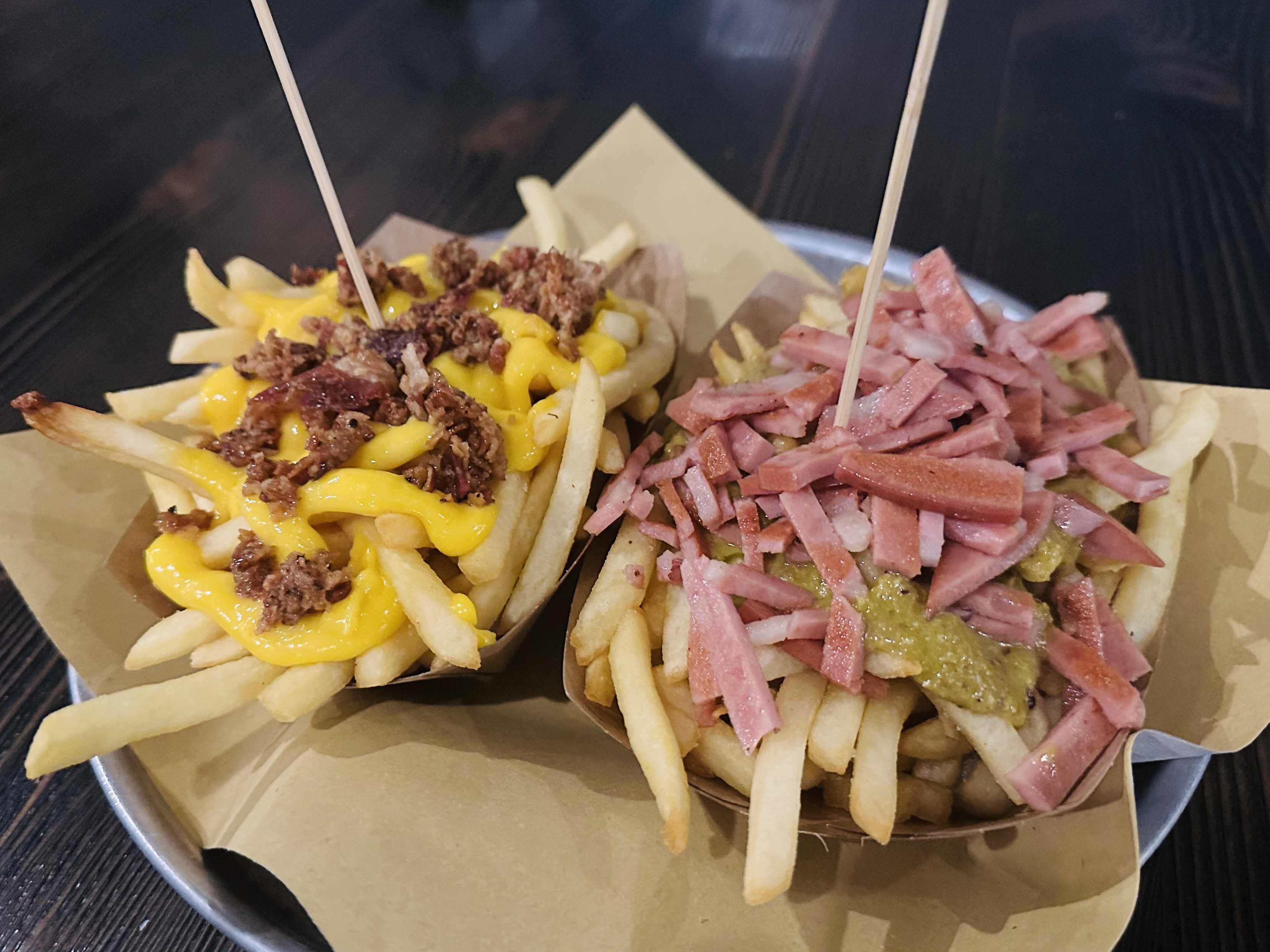 チーズとベーコンをのせたフライドポテト2種。