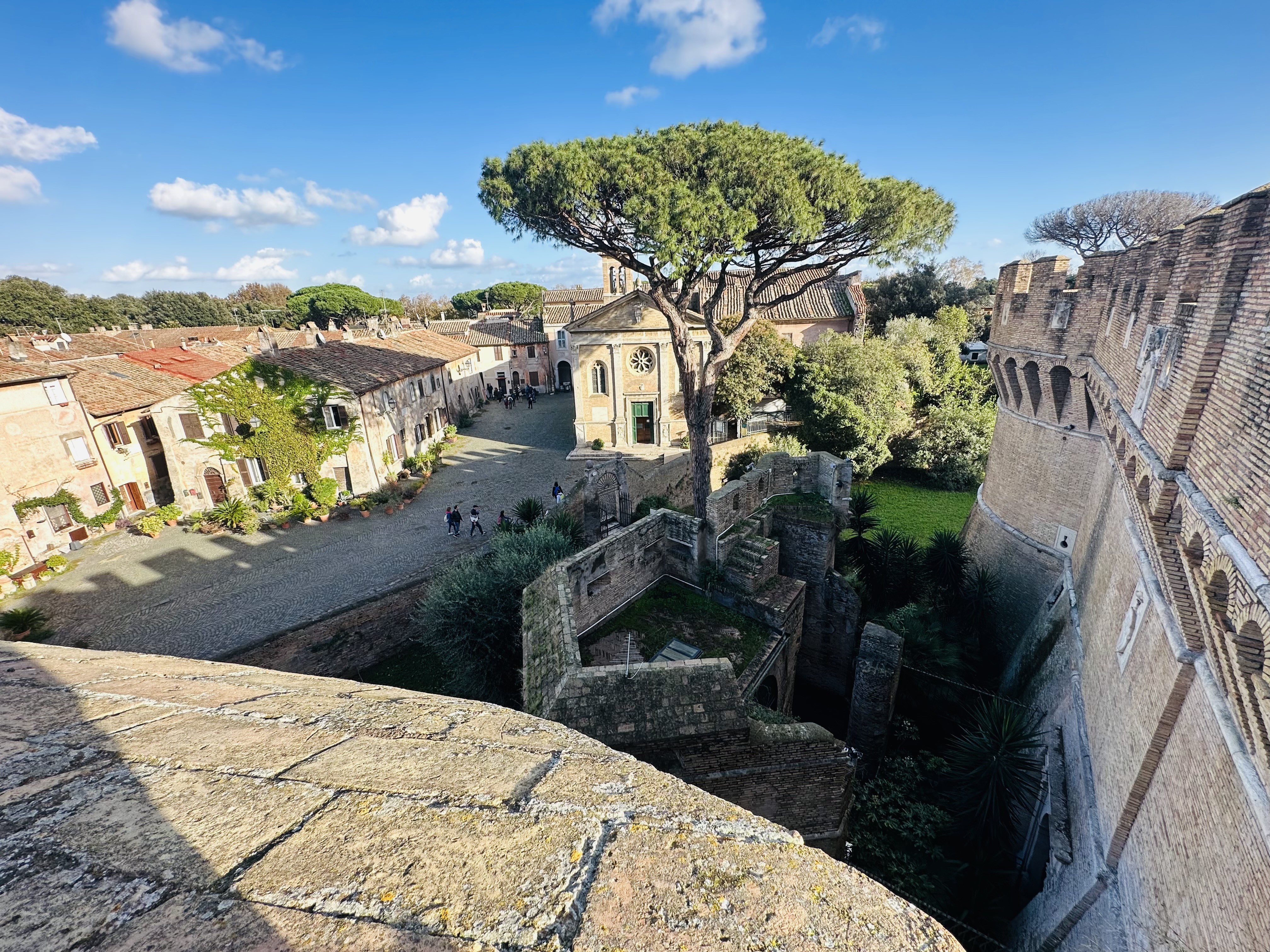 砦の屋上から見下ろすオスティアの村と遺跡へ続く緑の道
