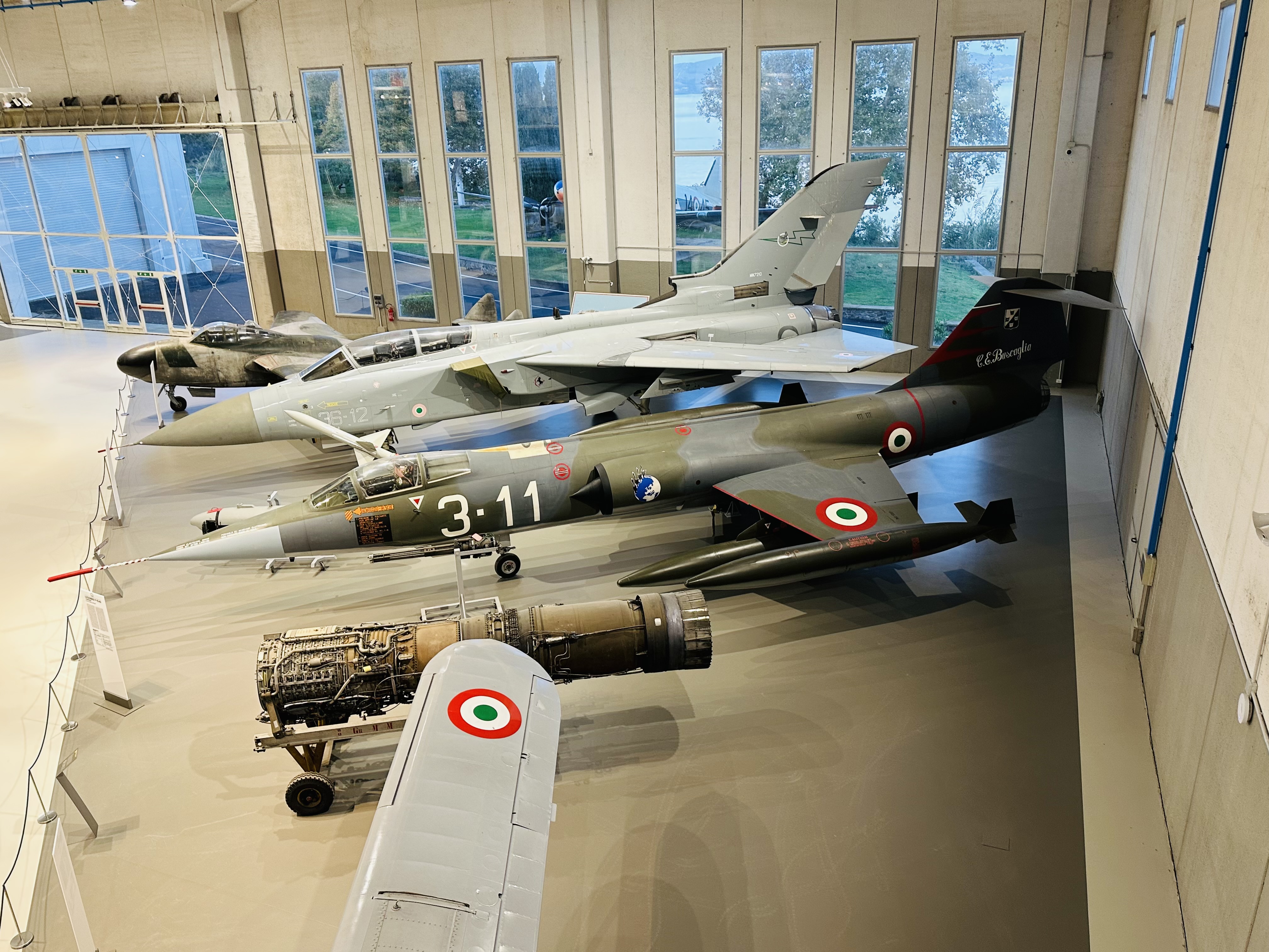 格納庫内部に静かに並ぶ複葉機と軍用機の展示